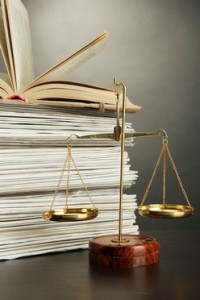 Gold scales of justice and folders on grey background