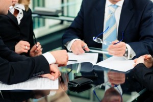 Business - meeting in an office; lawyers or attorneys discussing a document or contract agreement